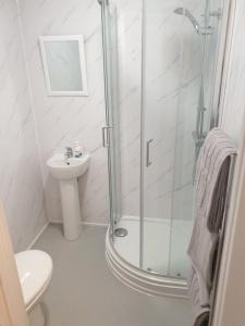 伊夫舍姆Bell Inn的带淋浴和盥洗盆的白色浴室
