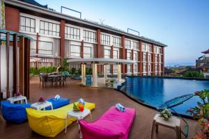 努沙杜瓦易昂巴厘岛贝诺酒店的一座带游泳池和椅子的酒店和一座建筑
