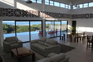 Viseisei斐济蓝宝湾别墅的客厅配有沙发、椅子和桌子