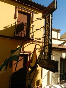 隆达斗牛场酒店的大楼前有旗帜的餐厅标志