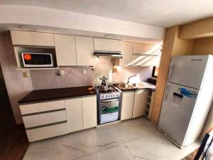 拉巴斯Zona Sur - Acogedor departamento completo - URBEANDINA的小厨房配有炉灶和冰箱
