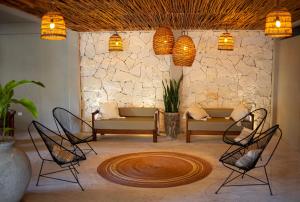 玛哈威Noah Beach Hotel & Suites的客厅配有椅子和石墙