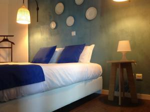 罗当旧镇Vilaportuguesa的一间卧室配有一张带蓝色和白色枕头的床