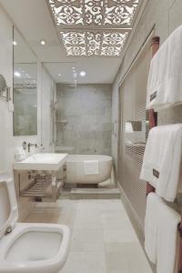 马六甲Sojourn Guest House Melaka的白色的浴室设有浴缸、水槽和浴缸。