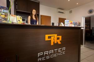 布达佩斯Prater Residence Apartment的站在打印机餐厅柜台的女人