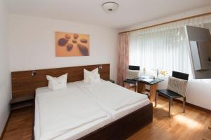 弗伦斯堡阿姆水塔酒店的卧室配有一张白色大床和一张书桌