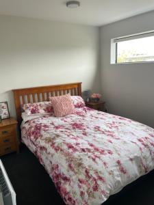 基督城Bealey Avenue Apartment, 2 Bedroom apartment, Central City的一间卧室配有一张带花卉床罩的床和窗户。