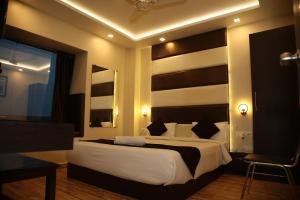 加尔各答Hotel Sheldon International Near Science City的卧室配有一张带白色床单和枕头的大床。