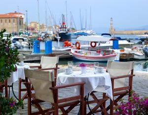 干尼亚Porto Veneziano Hotel的码头上带船只的桌椅