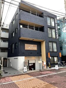 东京VACATION INN HEIWAJIMA I的一座黑色的建筑,旁边有一个标志