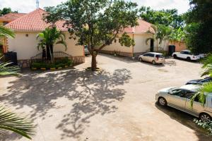 坎帕拉Etana Motel Kampala的房屋前设有停车场,可停放汽车