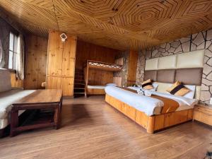 西姆拉Hotel Victory的一间卧室设有两张床和木制天花板