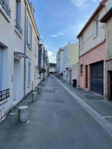 圣但尼WIFI- STADE DE FRANCE- BASILIQUE CATHEDRALE MONSEJOURASAINTDENIS的建筑物之间的小巷里一条空的街道