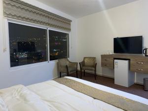瓦迪穆萨Asad Apt.的酒店客房设有一张床和一个大窗户