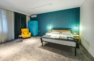 第比利斯Betlemi Hotel的一间卧室配有一张床和一张黄色椅子