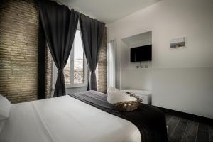 罗马拱形罗马套房旅馆的一间卧室设有一张大床和一个窗户。