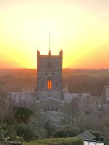 圣大卫St Davids Gin & Kitchen - The Cathedral Villas的一座古建筑,背景是日落