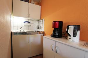奥斯赛拜-屈隆斯博恩Ferienhaus Beyer的厨房配有水槽和台面上的咖啡壶