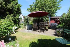 奥斯赛拜-屈隆斯博恩Ferienhaus Beyer的庭院配有桌椅和遮阳伞。