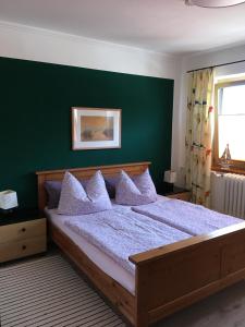 奥斯赛拜-屈隆斯博恩Ferienwohnung Dünensand的一间卧室设有一张大床和绿色的墙壁