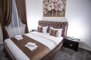 巴亚马雷The Nest Baia Mare的一间卧室配有一张大床和两条毛巾