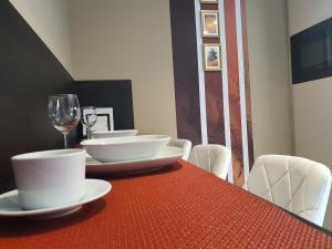 考波什堡Kaposvár Apartman的红桌,带白板和一杯葡萄酒
