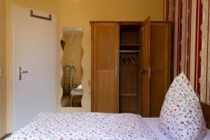 奥斯赛拜-屈隆斯博恩Ferienwohnung Elke的一间卧室配有一张床和一个木制衣柜