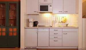 奥斯赛拜-屈隆斯博恩Ferienwohnung Parkblick Nr. 22的厨房配有白色橱柜和微波炉