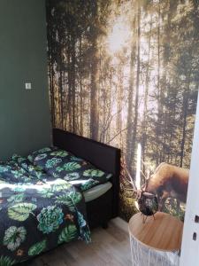 BoylVakantieverhuur Bienvenue的一间卧室设有一张床和一个树木繁茂的窗户