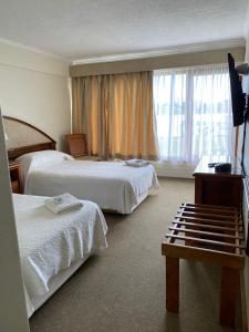 瓦尔迪维亚Villa del Rio Express的酒店客房设有两张床和窗户。