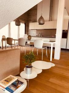 PrêlesHotel de l’Ours Preles的厨房配有白色的桌椅和植物桌子