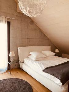 PrêlesHotel de l’Ours Preles的卧室配有一张白色大床和吊灯。
