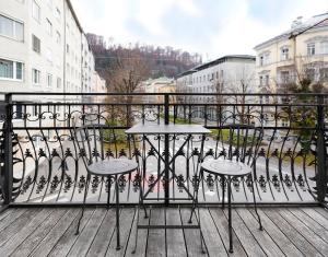 萨尔茨堡numa l Mozart的阳台配有一张桌子和两把椅子