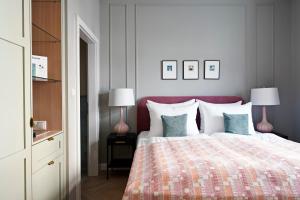 萨尔茨堡numa l Mozart的一间卧室配有一张带粉红色床头板的床和两盏灯。
