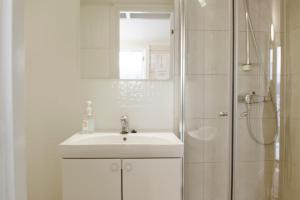 NesnaTopcamp Havblikk - Helgeland的白色的浴室设有水槽和淋浴。