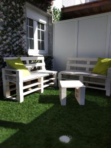 卡马里尼亚斯斯黛拉德玛尔旅馆的庭院设有两把椅子、一张长凳和一张桌子
