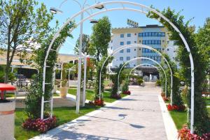 卡西诺Edra Palace Hotel & Ristorante的公园内有白色拱门的走道