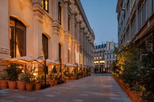 巴黎Hôtel Madame Rêve的一条空荡荡荡的街道,上面有雨伞和盆栽植物