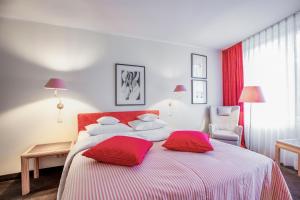 茨魏布肯法萨奈瑞兰德城堡罗曼蒂克酒店的一间卧室配有一张带红色枕头的大床