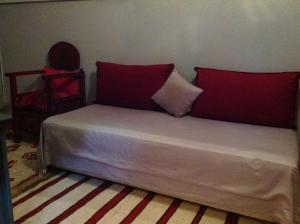 马拉喀什里亚德西霸旅馆的一张床上有两个红色枕头的房间