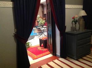 马拉喀什里亚德西霸旅馆的通往带桌子的客厅的开放式门