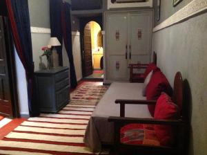 马拉喀什里亚德西霸旅馆的一间卧室,卧室内配有一张床和一把椅子