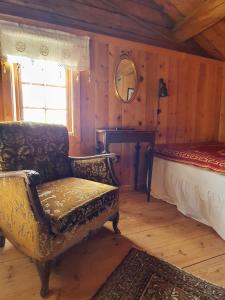 勒罗斯奥尔比戈登度假屋的一间卧室配有一张床、一把椅子和镜子