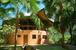 乌维塔Manoas的前面有棕榈树的房子