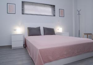 卡图亚该亚Sea & View Villas的一间卧室配有一张带粉色毯子的大床
