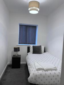 曼彻斯特Amersham Park Apartment的卧室配有白色的床和窗户。