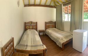 蒂拉登特斯Pouso dos Querubins的一间卧室设有两张床和窗户。