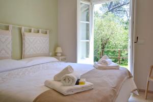 卡莫利I Giardini di Camogli - VILLA SÀRVIA, garden&pool的一间卧室配有两张床、毛巾和窗户