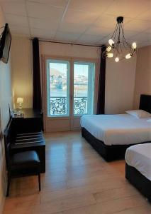 罗纳河畔的图尔农城堡酒店的酒店客房设有两张床和窗户。