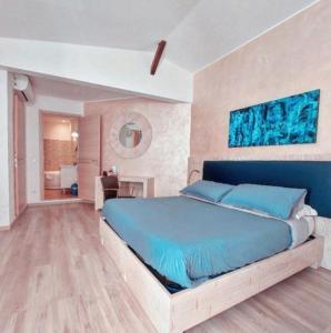圣雷莫Locanda Sapori的一间带蓝色床的卧室和一间浴室